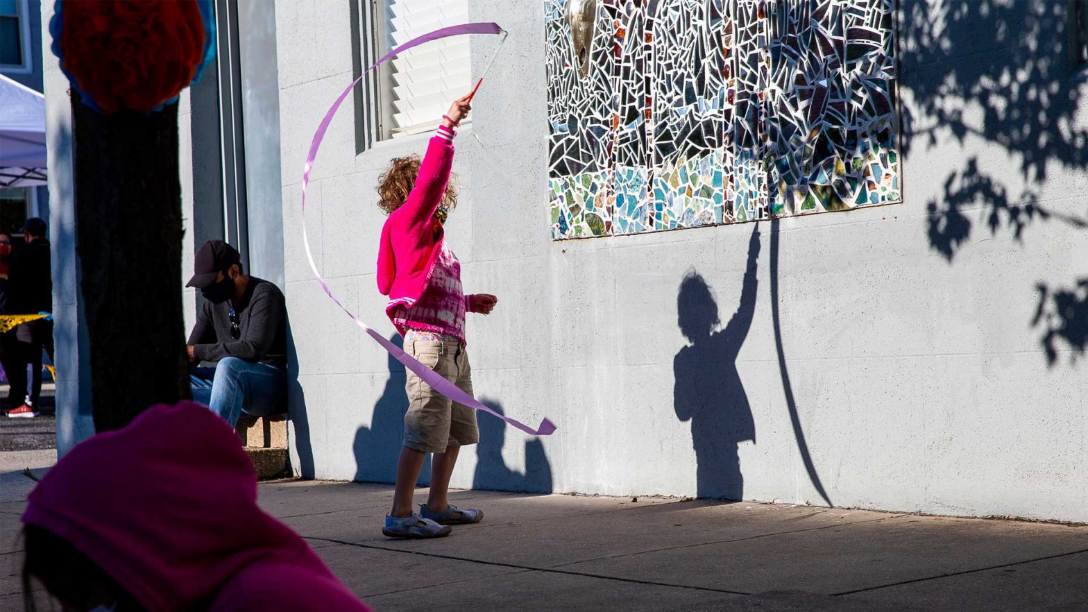 Child twirling a streamer at a street fair